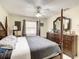 Bedroom showcasing a four-poster bed, ceiling fan, and a dresser with a mirror at 624 Royal Palm Dr, Kissimmee, FL 34743