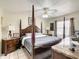 Spacious primary bedroom with a four poster bed, ceiling fan, and dresser at 624 Royal Palm Dr, Kissimmee, FL 34743