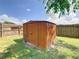 Durable backyard shed for storage, complemented by a fenced yard and green grass at 624 Royal Palm Dr, Kissimmee, FL 34743