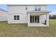 Exterior view of the back of the home and covered patio, overlooking the grassy backyard at 630 Summit River Dr, Apopka, FL 32712