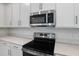Close-up of a kitchen featuring stainless steel appliances and white cabinets at 630 Summit River Dr, Apopka, FL 32712
