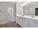 Bathroom featuring double sinks, white cabinetry, walk-in shower, and wood-look tile at 640 Summit River Dr, Apopka, FL 32712