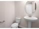 Neat powder room featuring a pedestal sink, oval mirror and a modern toilet at 640 Summit River Dr, Apopka, FL 32712