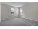 A bright bedroom featuring two windows and neutral gray walls and carpet at 640 Summit River Dr, Apopka, FL 32712