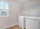 Bright laundry room with new washer and dryer, wood-look tile, and natural light at 640 Summit River Dr, Apopka, FL 32712