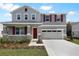Charming two-story home with a well-manicured lawn and a two-car garage with red shutters at 655 Summit River Dr, Apopka, FL 32712