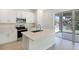 Modern kitchen featuring white cabinets, stainless steel appliances, and a large island with a sink at 655 Summit River Dr, Apopka, FL 32712