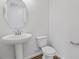 Clean half bathroom featuring a pedestal sink, sleek fixtures, toilet, and wood-look flooring for a modern touch at 660 Summit River Dr, Apopka, FL 32712