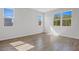 Bright, airy bedroom features three large windows, fresh neutral paint, and sleek wood-look tile flooring at 660 Summit River Dr, Apopka, FL 32712