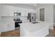 Modern kitchen with white cabinets, stainless steel appliances, quartz countertops, and a central island at 660 Summit River Dr, Apopka, FL 32712