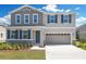 Charming two-story home features a two-car garage, stone accents, neutral colors, and a well-maintained front yard at 665 Summit River Dr, Apopka, FL 32712