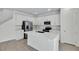 Modern kitchen with white cabinets, stainless steel appliances, a large island, and wood-look flooring at 665 Summit River Dr, Apopka, FL 32712