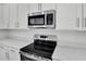 Stainless steel oven and microwave in this modern kitchen with white cabinets and light countertops at 665 Summit River Dr, Apopka, FL 32712