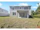 Spacious backyard with covered patio and modern exterior of the gray and white home at 675 Summit River Dr, Apopka, FL 32712