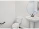 Clean, half bathroom showcasing a pedestal sink, round mirror, and modern fixtures at 675 Summit River Dr, Apopka, FL 32712