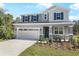 Charming two-story home featuring a gray exterior, two-car garage, and well-manicured landscaping at 675 Summit River Dr, Apopka, FL 32712