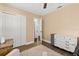 A cozy bedroom with a plush rug, white dresser, closet, and wood-look flooring at 736 Forest Glen Ct, Maitland, FL 32751