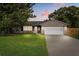 Charming single-story home featuring a well-manicured lawn and an attached two-car garage at 736 Forest Glen Ct, Maitland, FL 32751