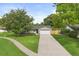 A well-kept home with a beautiful lawn and a long driveway leading to the attached garage at 736 Forest Glen Ct, Maitland, FL 32751