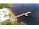 Breathtaking aerial view of a dock extending into the serene lake, adjacent to a sandy beach with inviting lounge chairs at 1106 Gran Bahama Blvd # 1106, Davenport, FL 33897