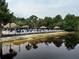 Scenic view of the beach area with lounge chairs, palm trees, and thatched umbrellas near the lake at 1106 Gran Bahama Blvd # 1106, Davenport, FL 33897
