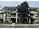 Three-story condo building featuring white stairs, lush landscaping and unit number 26 at 1106 Gran Bahama Blvd # 1106, Davenport, FL 33897