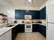 Bright kitchen boasts navy blue cabinets, white countertops, and stainless steel appliances at 1106 Gran Bahama Blvd # 1106, Davenport, FL 33897