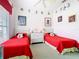 Charming bedroom featuring two twin beds with bright red bedding and playful Mickey Mouse decor at 116 Westport Ln, Davenport, FL 33896