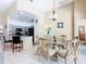 Charming dining area features a glass table, chandelier, and barstool seating at the kitchen counter at 116 Westport Ln, Davenport, FL 33896