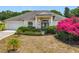 Charming single-story home with lush landscaping and bright pink bougainvillea in the front yard at 116 Westport Ln, Davenport, FL 33896