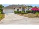 Single-story home with attached garage, columned entryway, and colorful landscaping at 116 Westport Ln, Davenport, FL 33896