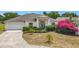 Inviting single-story home showcasing a manicured lawn with vibrant landscaping and a comfortable driveway at 116 Westport Ln, Davenport, FL 33896