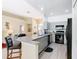 Stylish kitchen boasts gray cabinets, black appliances, granite countertops, and an adjacent living area at 116 Westport Ln, Davenport, FL 33896