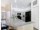 Modern kitchen features gray cabinets, black appliances, granite countertops, and a breakfast bar at 116 Westport Ln, Davenport, FL 33896