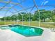 Clear, screened-in pool with an attached spa, perfect for relaxing and enjoying the backyard view at 116 Westport Ln, Davenport, FL 33896
