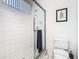 Shower room featuring a glass door and white tiled walls at 116 Westport Ln, Davenport, FL 33896