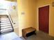 Exterior entryway with a red door, seating bench and a staircase leading to the upper floor at 1325 Lake Shadow Cir # 12205, Maitland, FL 32751