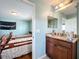 Well-lit bathroom with a granite countertop vanity adjacent to a bedroom with two twin beds, offering convenience and comfort at 16072 Shasta St, Clermont, FL 34714