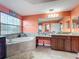 Bathroom featuring separate vanities, soaking tub, and large window for natural light at 16072 Shasta St, Clermont, FL 34714