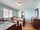 Bedroom with wood flooring, two twin beds, and a bathroom ensuite at 16072 Shasta St, Clermont, FL 34714