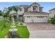 Beautiful two-story home with a well-manicured lawn, water fountain, and a three-car garage at 16072 Shasta St, Clermont, FL 34714
