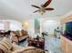 Open living space with couches, a decorative fan, and a staircase leading to the second floor at 16072 Shasta St, Clermont, FL 34714