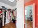 Spacious walk-in closet with ample shelving, storage, and natural light, connected to a room with hardwood floors at 16072 Shasta St, Clermont, FL 34714