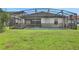 The backyard of the home features a screened-in pool and a well manicured lawn at 163 Kenny Blvd, Haines City, FL 33844