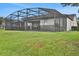 Backyard with a screened-in patio over a pool, perfect for outdoor entertaining and relaxation at 163 Kenny Blvd, Haines City, FL 33844