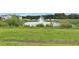 Spacious backyard with lush green grass and a scenic pond with fountain at 163 Kenny Blvd, Haines City, FL 33844