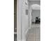 Hallway with light tile and gray walls, featuring arched doorways and modern fixtures at 163 Kenny Blvd, Haines City, FL 33844
