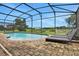 Private screened-in pool area with brick pavers and relaxing lounge chairs at 163 Kenny Blvd, Haines City, FL 33844