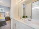 A spacious bathroom boasts double sinks, white cabinets, and a mirror that reflects the bedroom at 1810 Caribbean View Ter, Kissimmee, FL 34747