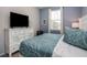 Bedroom features plenty of natural light from the large window and a large TV on a console at 1810 Caribbean View Ter, Kissimmee, FL 34747